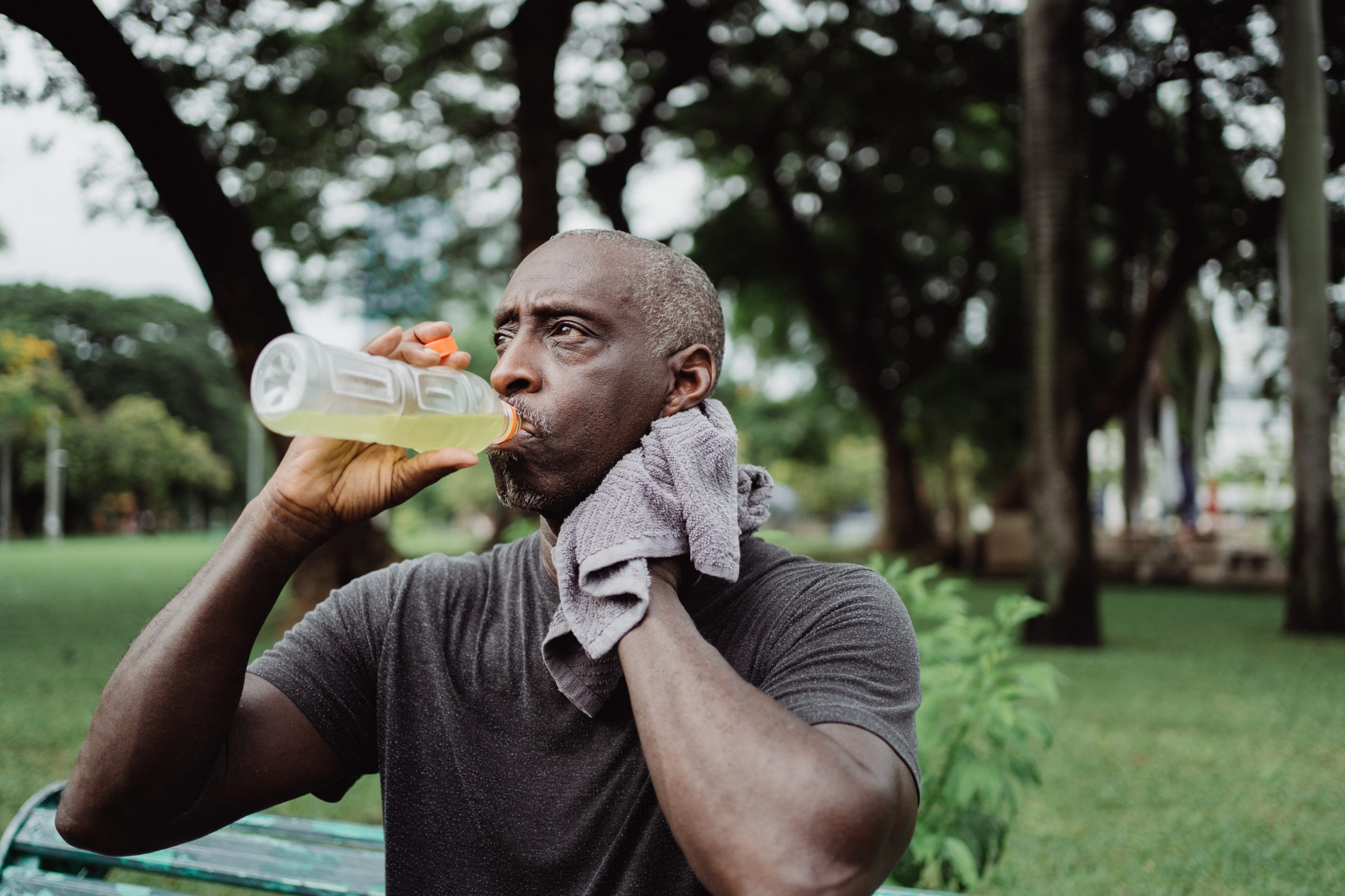 man drinking gatorade after exercising outside